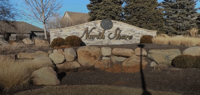 Entrance sign for the North Shore neighborhood in Papillion, Nebraska, surrounded by landscaping and set against a bright sky, welcoming visitors and residents to this sought-after community.