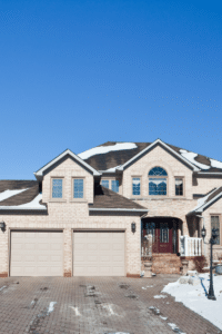 A cozy home covered in snow, showcasing the charm of selling your home in winter with a warm and inviting exterior.